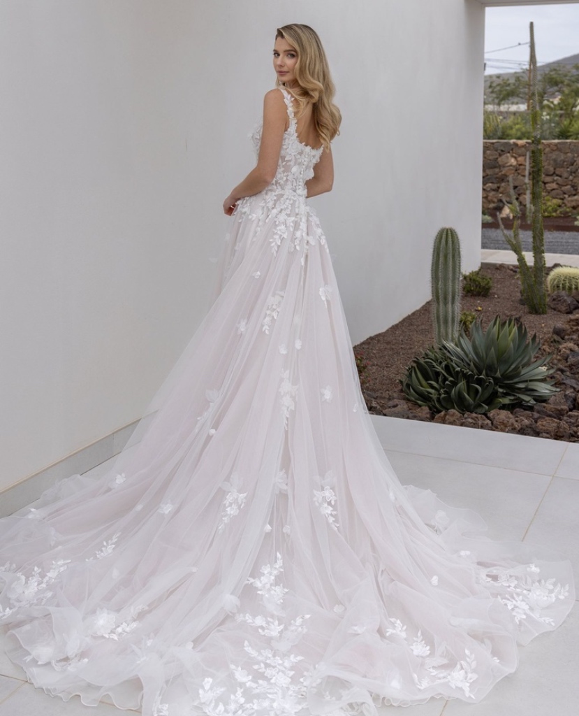Rückansicht eines A-Linien Brautkleides mit eckigem Ausschnitt, verziert mit floralen 3D-Applikationen und einer weiten Tüllschleppe, vom Brautladen Brittanja aus Moers.