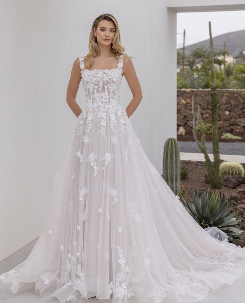 Romantisches A-Linien Brautkleid mit modernem eckigem Ausschnitt und zarten floralen 3D-Blüten auf feinem Tüll, vom Brautladen Brittanja aus Moers.