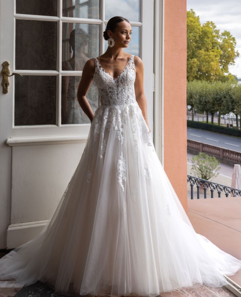Klassisches A-Linien Brautkleid mit tiefem V-Ausschnitt, besticktem Spitzen-Oberteil und voluminösem Glitzer-Tüllrock, vom Brautladen Brittanja aus Moers.