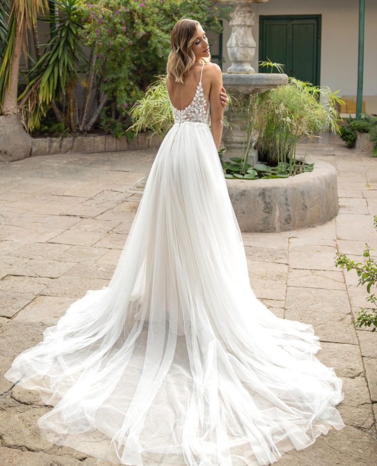 Rückenansicht eines Boho-Brautkleides mit tiefem V-Rückenausschnitt, zarten Spitzen-Details und einer eleganten Schleppe, vom Brautladen Brittanja aus Moers.