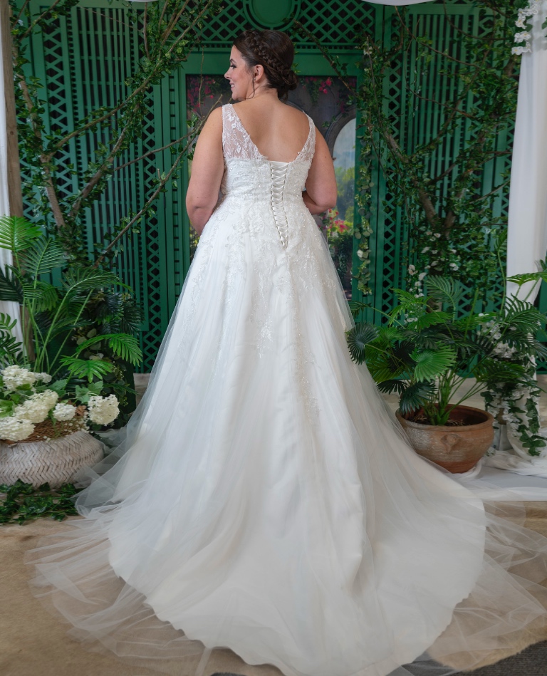 Rückenansicht eines Curvy-Brautkleides mit klassischer Korsett-Schnürung und einer weich fallenden Tüllschleppe, erhältlich bei Brittanja in Moers.