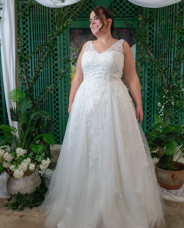 Bezauberndes Curvy-Brautkleid in A-Linie mit V-Ausschnitt und herabfallenden Spitzenapplikationen, präsentiert von Brittanja Moers.