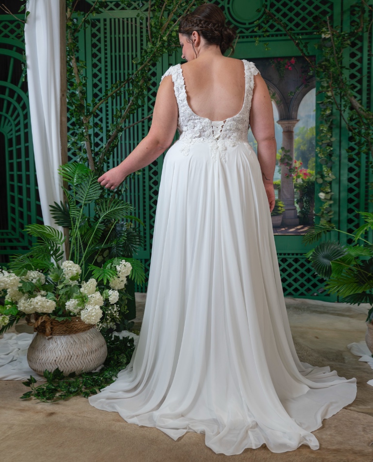 Rückansicht eines Curvy-Brautkleides mit tiefem Rückenausschnitt, dezenter Korsett-Schnürung und leichtem Rock, von Brittanja in Moers.