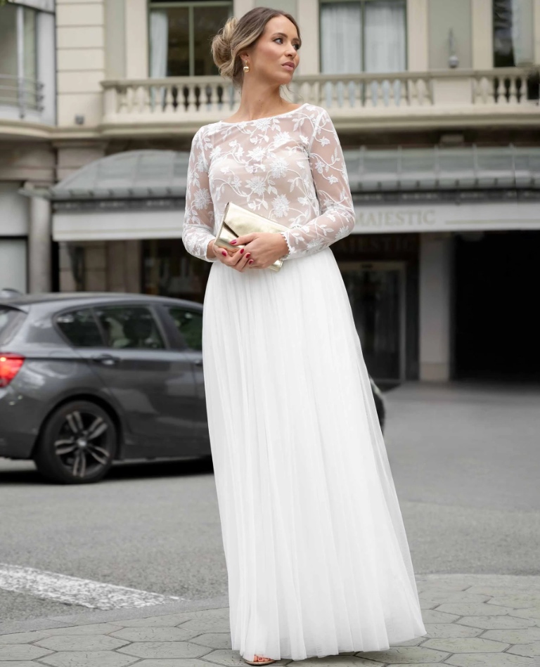 Eleganter Standesamt-Look bestehend aus einem langärmeligen Oberteil aus floraler Spitze und einem schlichten, weißen Maxirock, von Brittanja Moers.